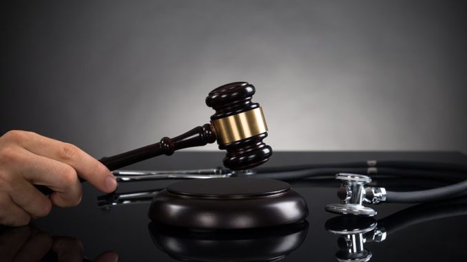 bigstock-Close-up-Of-Hands-With-Gavel-A-98660933